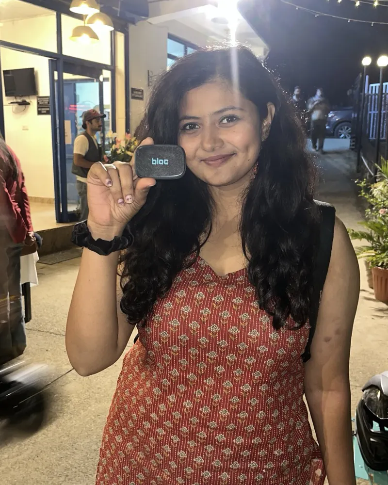 A bloc owner under warm string lights at night, holding her bloc beside her face