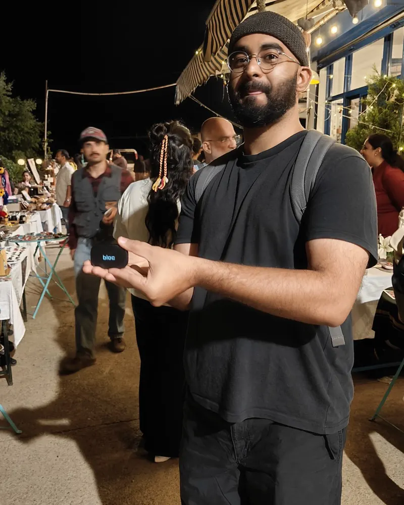 A bloc owner at a night market with his bloc resting on his open palm